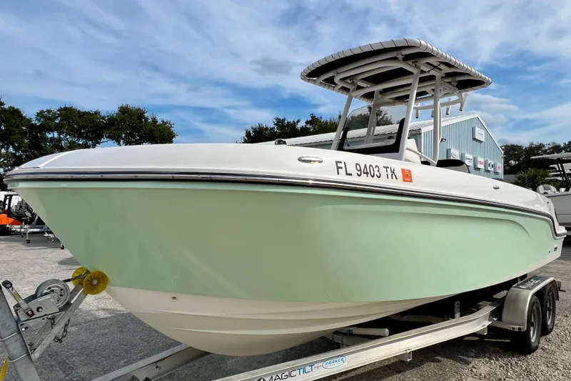 Slide: The Image of 2023 Trophy T24CC boat on trailer, light green hull, parked outdoors. - 4