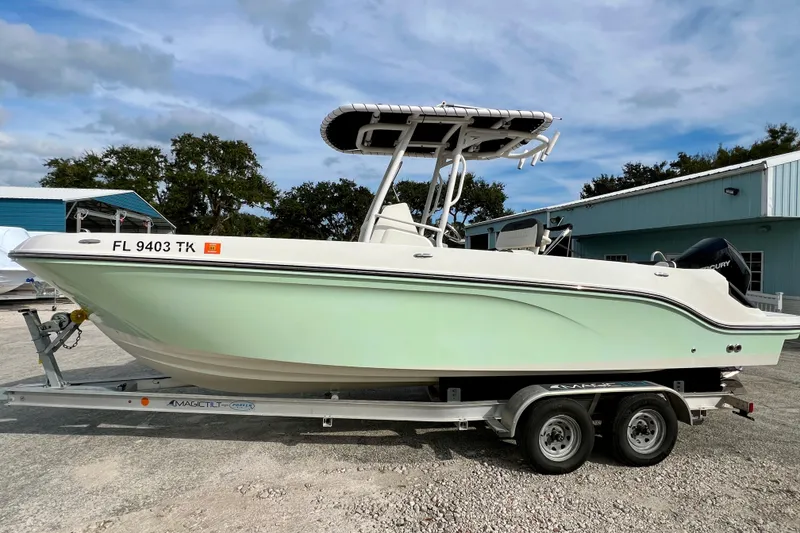 Slide: The Image of 2023 Trophy T24CC boat on trailer, parked outdoors, side view. - 5