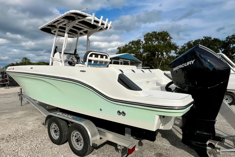 Slide: The Image of 2023 Trophy T24CC boat on trailer with Mercury outboard motor, parked outdoors. - 6