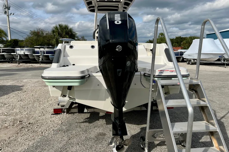 Slide: The Image of 2023 Trophy T24CC boat with outboard motor and ladder, parked outdoors. - 7