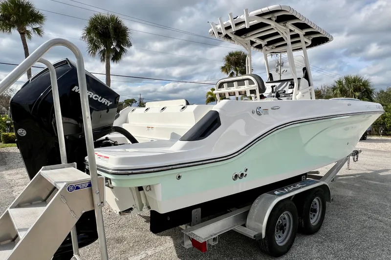 Slide: The Image of 2023 Trophy T24CC boat on trailer with Mercury engine, parked outdoors. - 8