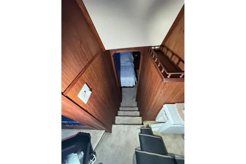 Slide: The Image of Interior view of 1986 Bluewater 46 MY yacht, featuring wooden stairs and cozy cabin. - 12