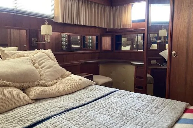Slide: The Image of Luxurious cabin interior of a 1986 Bluewater 46 MY yacht with cozy bedding and wood paneling. - 14