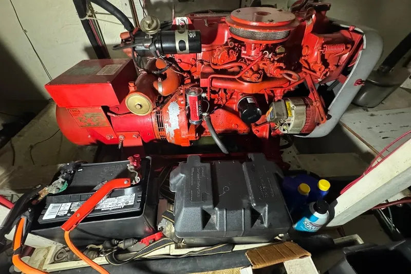 Slide: The Image of Engine compartment of a 1986 Bluewater 46 MY boat, featuring a red engine and battery setup. - 23