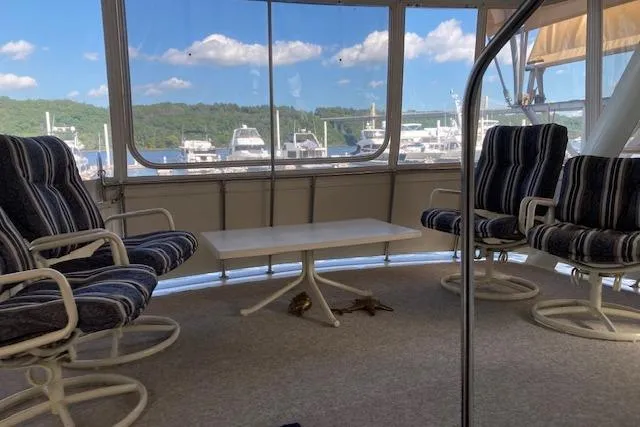 Slide: The Image of Interior of 1986 Bluewater 46 MY yacht with striped chairs and table, marina view. - 30