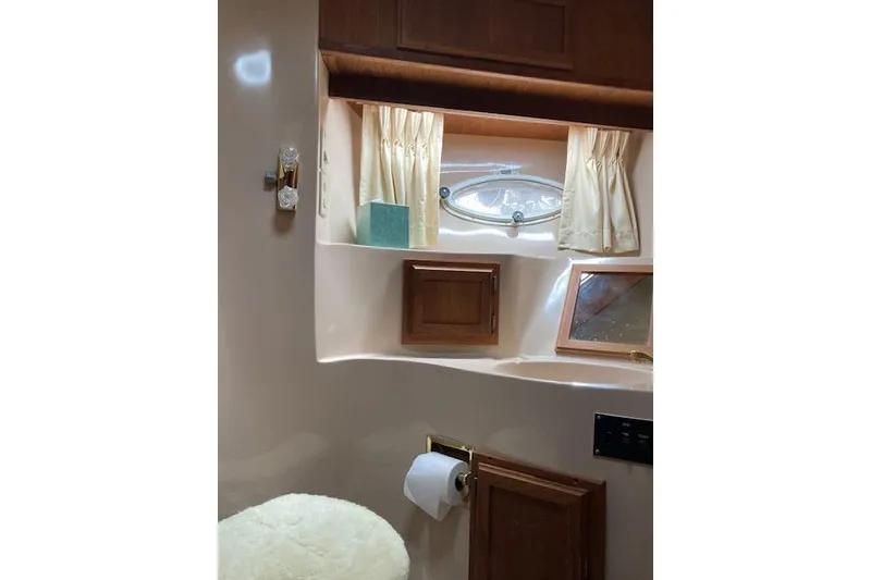 Slide: The Image of 1986 Bluewater 46 MY yacht bathroom with wooden cabinets and small window. - 6