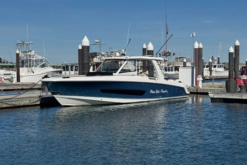 The Image of 2020 Boston Whaler 420 Outrage docked at marina under clear blue sky. - 0
