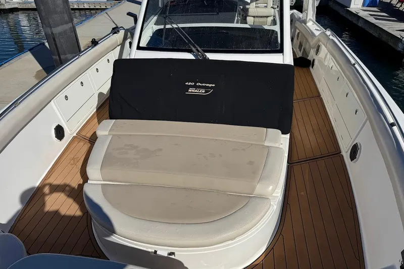 Slide: The Image of 2020 Boston Whaler 420 Outrage boat with cushioned seating and teak flooring. - 14