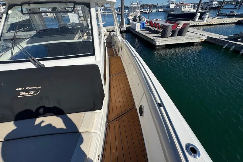 Slide: The Image of 2020 Boston Whaler 420 Outrage docked, showcasing sleek design and spacious deck. - 17