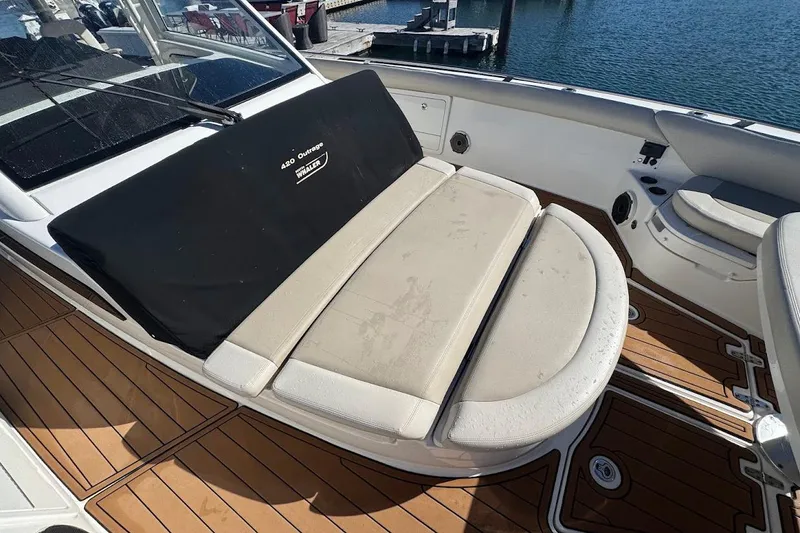 Slide: The Image of 2020 Boston Whaler 420 Outrage boat interior with cushioned seating and teak flooring. - 19