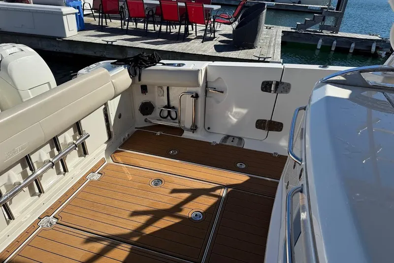 Slide: The Image of 2020 Boston Whaler 420 Outrage boat deck with teak flooring and dockside view. - 29
