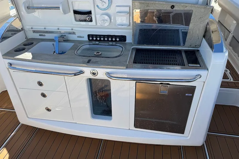 Slide: The Image of 2020 Boston Whaler 420 Outrage boat kitchen with sink, grill, and storage. - 31