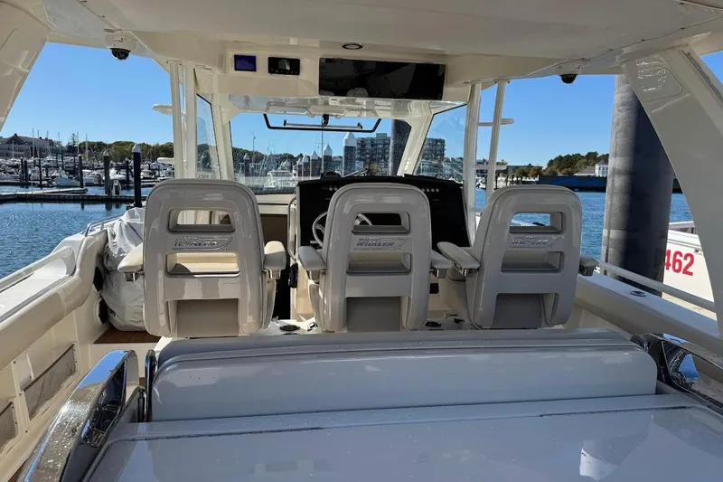 Slide: The Image of 2020 Boston Whaler 420 Outrage interior with helm seats, docked at marina. - 33