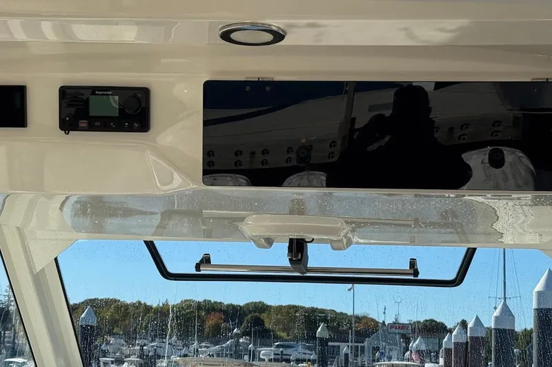 Slide: The Image of 2020 Boston Whaler 420 Outrage dashboard with navigation equipment and marina view. - 37