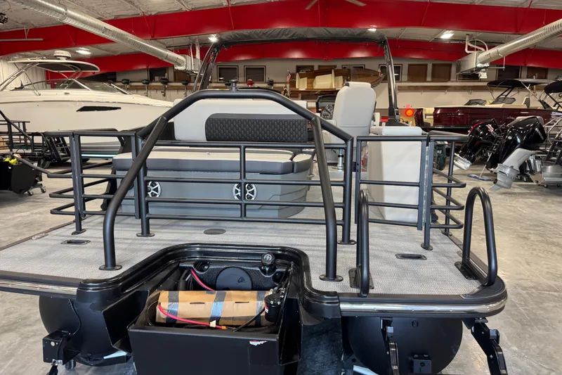 Slide: The Image of 2026 Sylvan L-5 Platinum pontoon boat in showroom, rear view with seating and railing. - 10