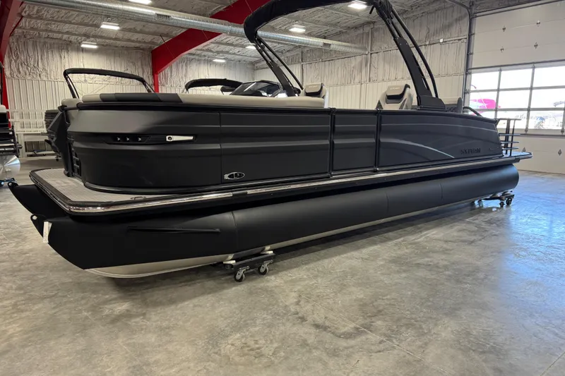 Slide: The Image of 2026 Sylvan L-5 Platinum pontoon boat in showroom, sleek black design. - 6