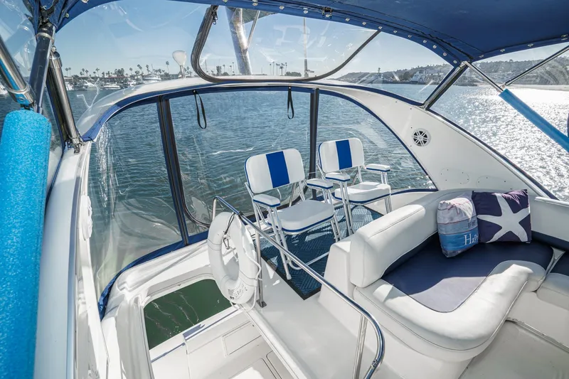 Slide: The Image of 2005 Meridian 381 Sedan yacht interior with blue and white seating, overlooking serene waters. - 9