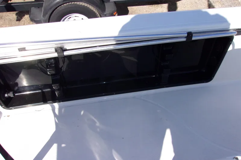 Slide: The Image of Open storage compartment on 2018 Blue Wave 2200 PureBay boat, trailer visible in background. - 12