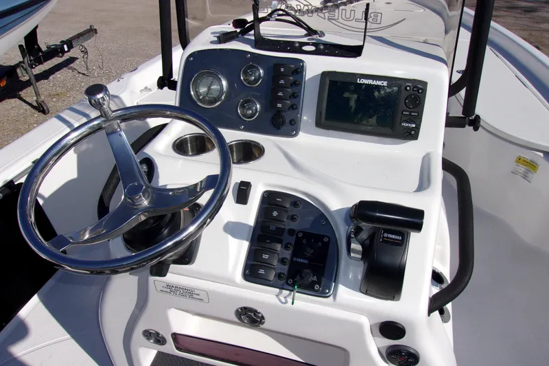 Slide: The Image of 2018 Blue Wave 2200 PureBay boat console with steering wheel and navigation controls. - 5