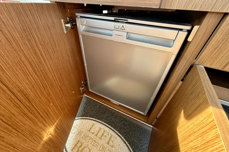 Slide: The Image of Compact fridge in 2022 Beneteau Antares 9 boat interior, wooden cabinetry. - 16