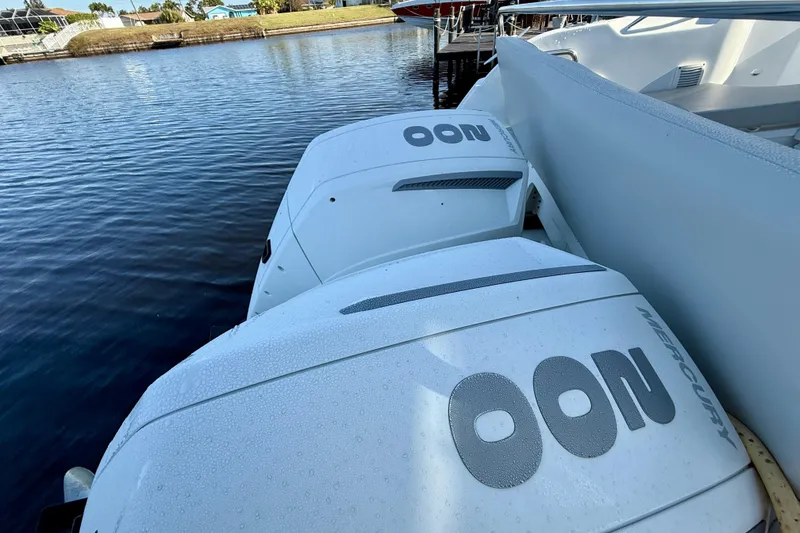 Slide: The Image of Twin Mercury outboard engines on a 2022 Beneteau Antares 9, docked by the water. - 3