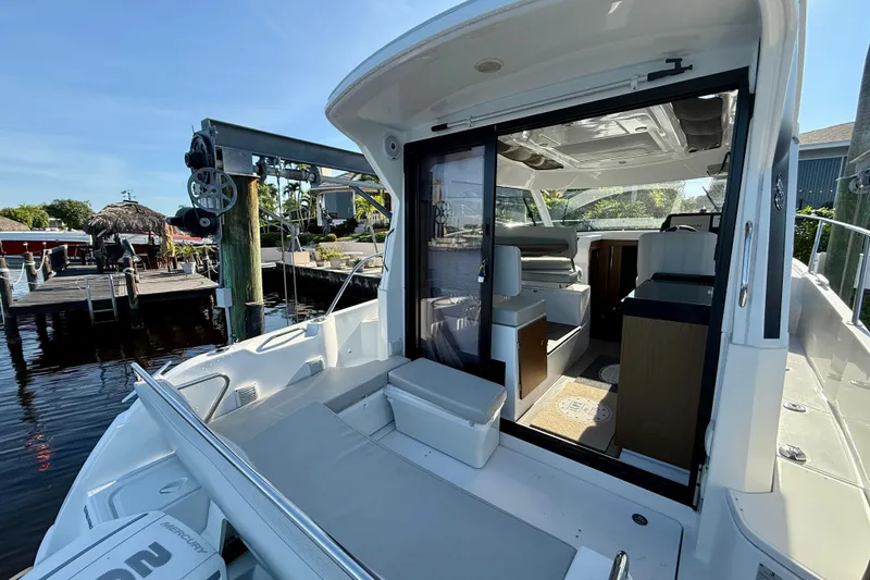 Slide: The Image of 2022 Beneteau Antares 9 boat interior with open sliding door, dockside view. - 5