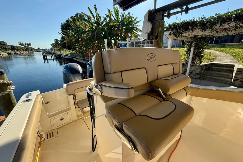 Slide: The Image of 2016 Scout 255 LXF boat interior with luxurious seating by a scenic waterfront. - 12