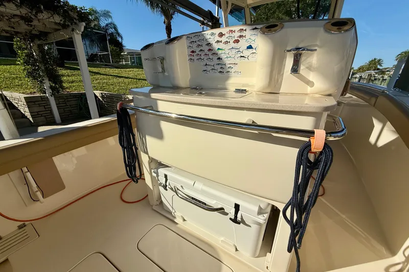 Slide: The Image of 2016 Scout 255 LXF boat interior with fishing gear and fish identification chart. - 13