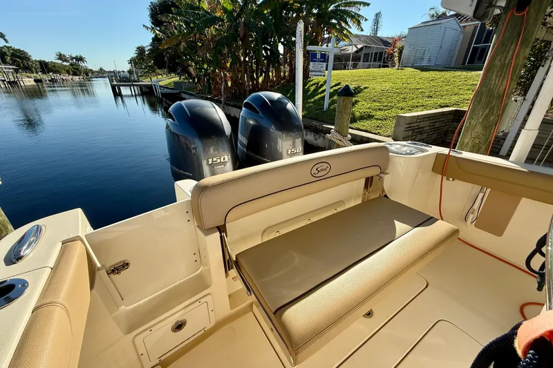 Slide: The Image of 2016 Scout 255 LXF boat with dual engines docked by a scenic waterfront. - 14