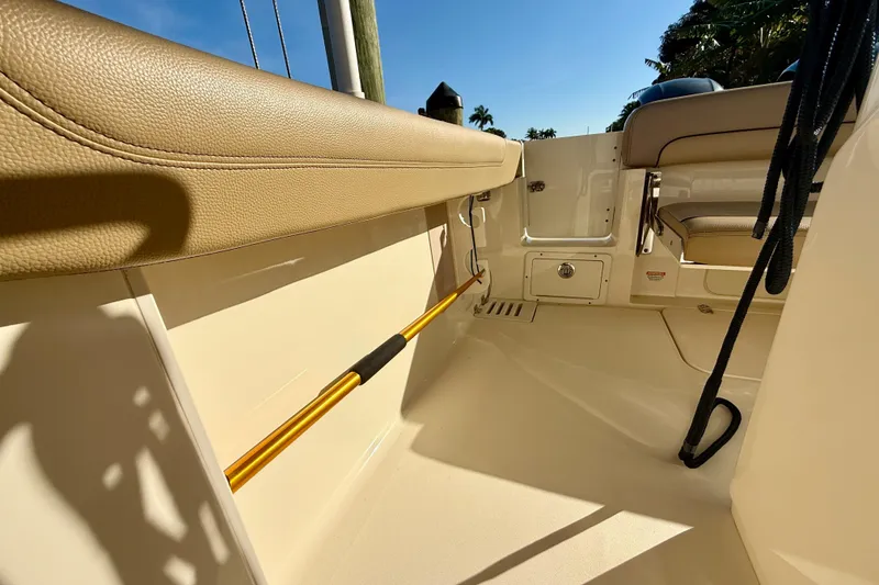 Slide: The Image of 2016 Scout 255 LXF boat interior with tan seating and storage compartments. - 15