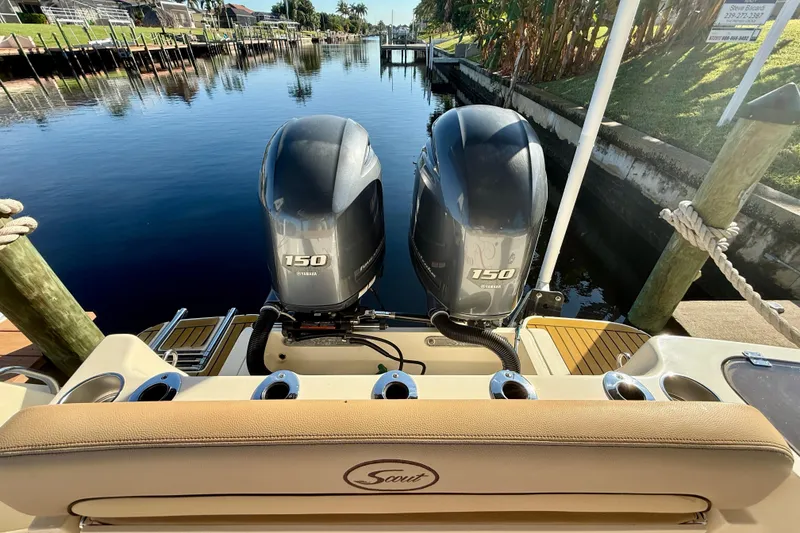 Slide: The Image of 2016 Scout 255 LXF boat with twin Yamaha 150 engines docked by a canal. - 6
