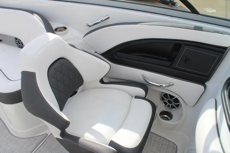 Slide: The Image of 2026 Crownline Eclipse E255 boat interior with white and black seating, cup holders, and speaker. - 22