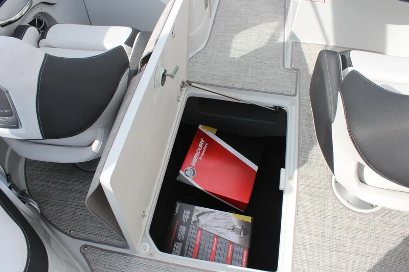 Slide: The Image of 2026 Crownline Eclipse E255 boat interior storage compartment with manuals. - 31