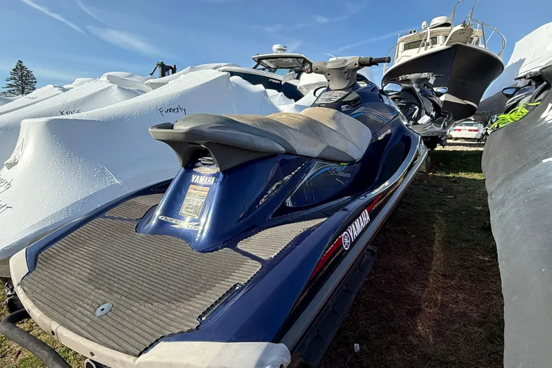 Slide: The Image of 2014 Yamaha WaveRunner VX Deluxe jet ski parked outdoors among boats. - 3