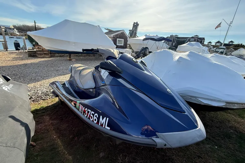 Slide: The Image of 2014 Yamaha WaveRunner VX Deluxe jet ski parked outdoors near covered boats. - 6