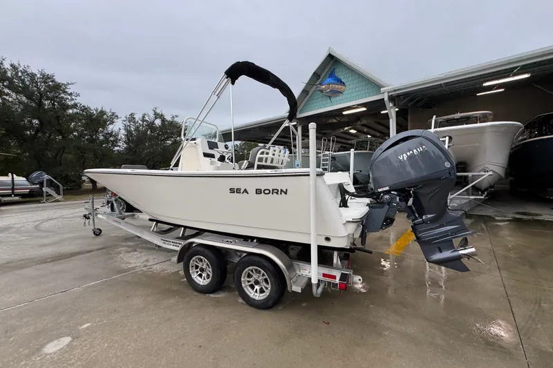 Slide: The Image of 2026 Sea Born LX21 Center Console boat on trailer, parked outdoors. - 15