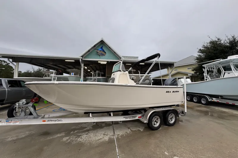 Slide: The Image of 2026 Sea Born LX21 Center Console boat on trailer at marina. - 2
