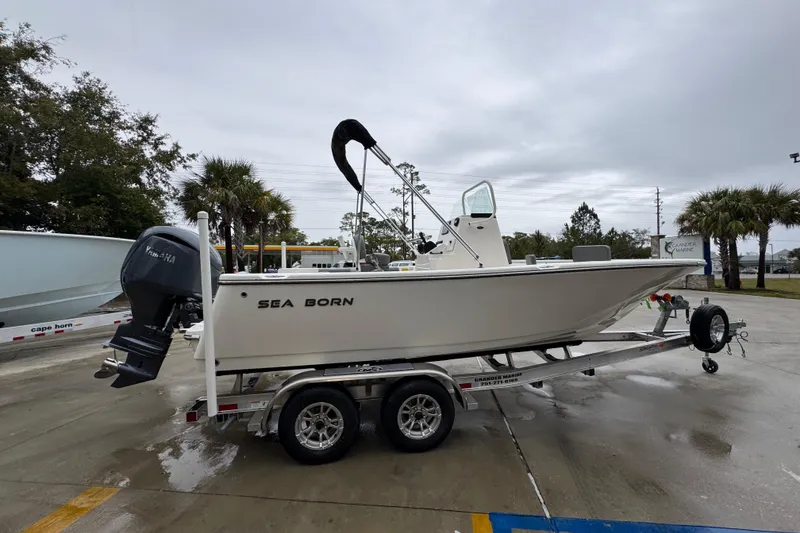 Slide: The Image of 2026 Sea Born LX21 Center Console boat on trailer, parked outdoors. - 9