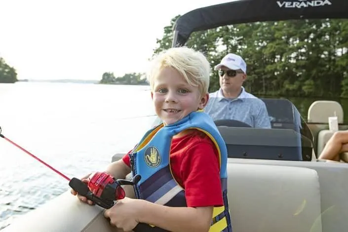 Slide: The Image of Child fishing on a 2026 Veranda Fish 22F2 boat, enjoying a sunny day on the water. - 6