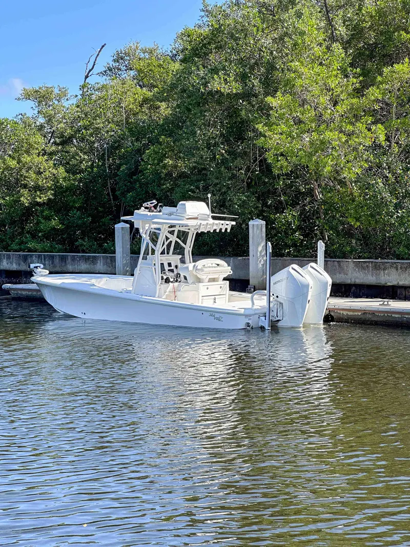Slide: The Image of 2022 SeaVee 270Z boat docked by lush greenery. - 11