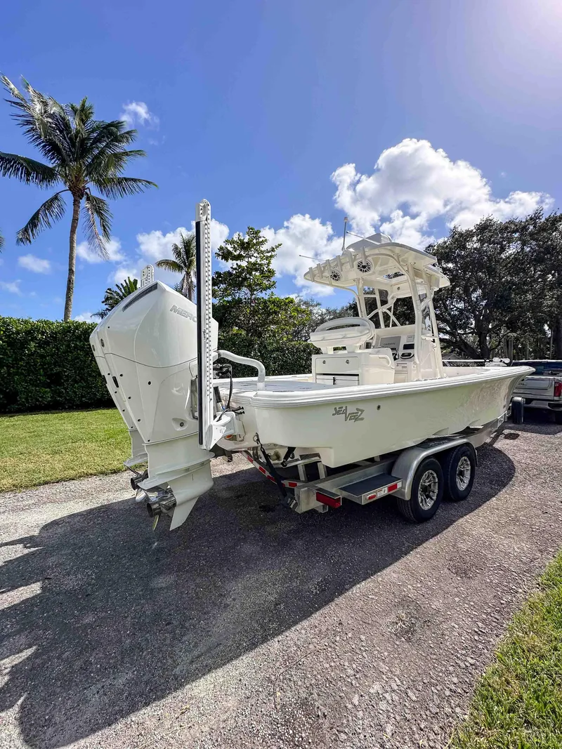 Slide: The Image of 2022 SeaVee 270Z boat on trailer, parked outdoors under a clear blue sky. - 13
