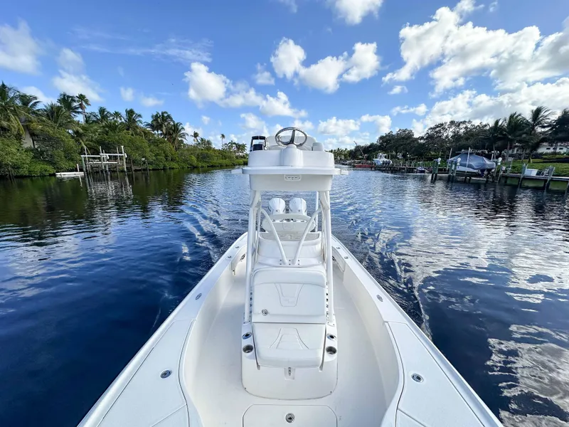 Slide: The Image of 2022 SeaVee 270Z boat cruising on a calm river under a blue sky with clouds. - 21