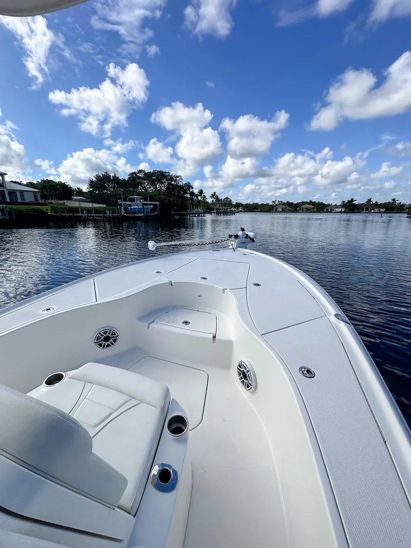 Slide: The Image of 2022 SeaVee 270Z boat on a calm lake under a blue sky with clouds. - 24