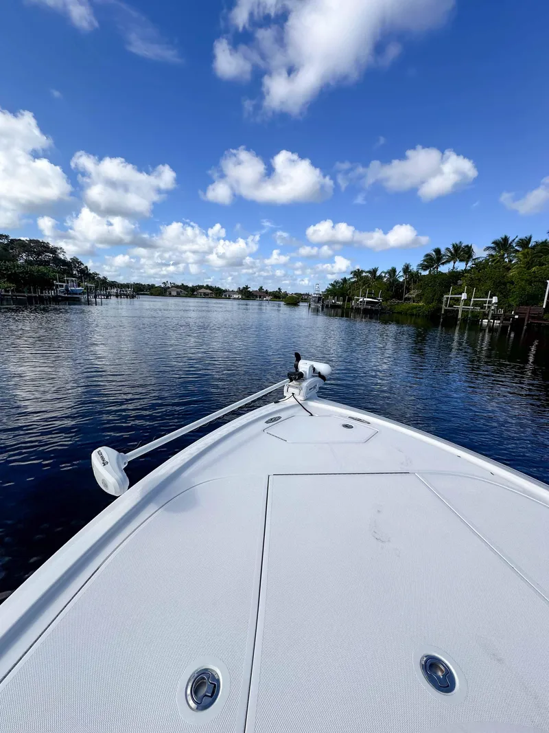 Slide: The Image of 2022 SeaVee 270Z boat on a calm river under a blue sky with clouds. - 27
