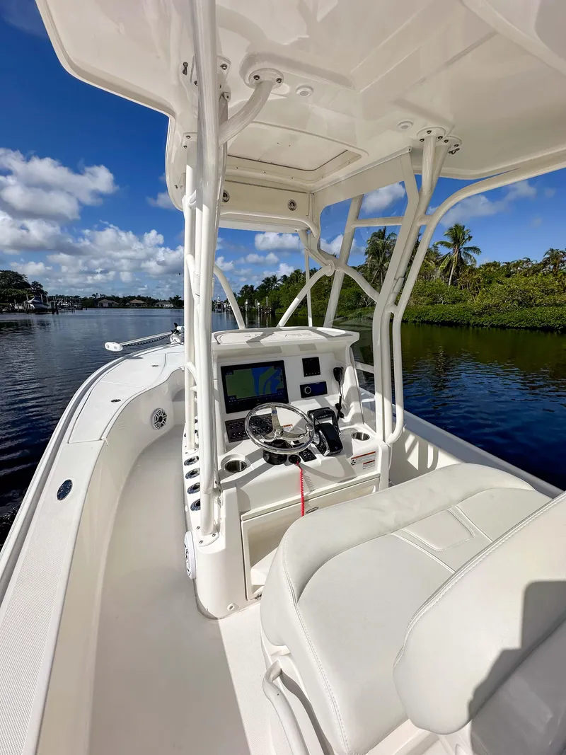 Slide: The Image of 2022 SeaVee 270Z boat interior with helm, on a calm waterway under blue skies. - 31