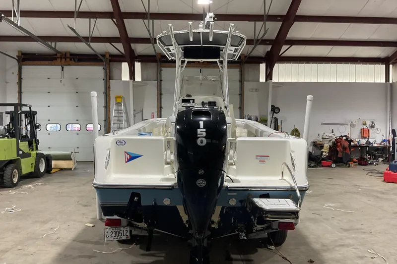 Slide: The Image of 2022 Mako 214 Center Console boat in a garage with outboard motor. - 10
