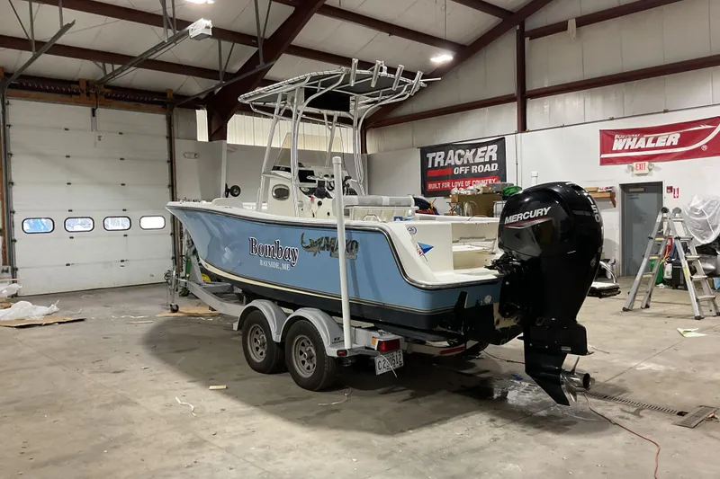 Slide: The Image of 2022 Mako 214 Center Console boat in garage with Mercury outboard motor. - 9