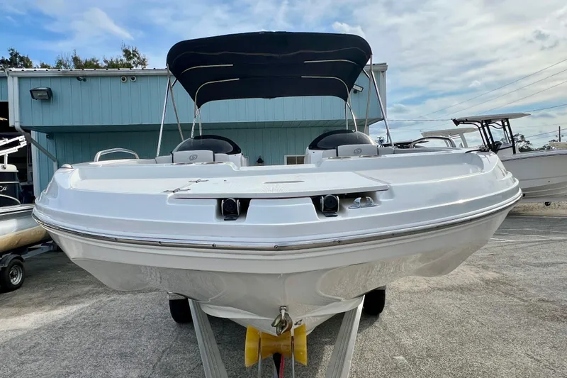 Slide: The Image of 2024 Hurricane Sundeck Sport 218 OB boat with canopy, parked outdoors. - 3