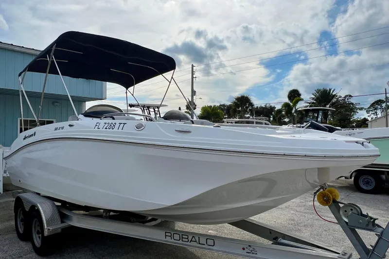 Slide: The Image of 2024 Hurricane Sundeck Sport 218 OB boat on trailer, with canopy, parked outdoors. - 4