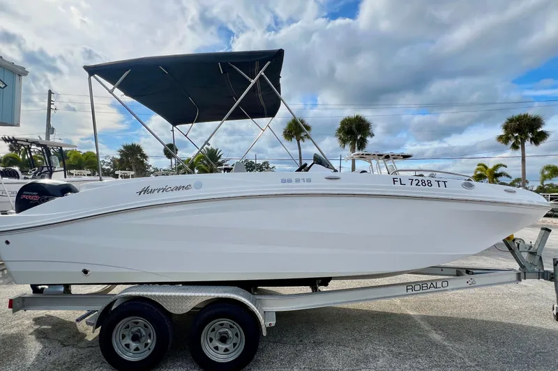 Slide: The Image of 2024 Hurricane Sundeck Sport 218 OB boat on trailer, under cloudy sky. - 5